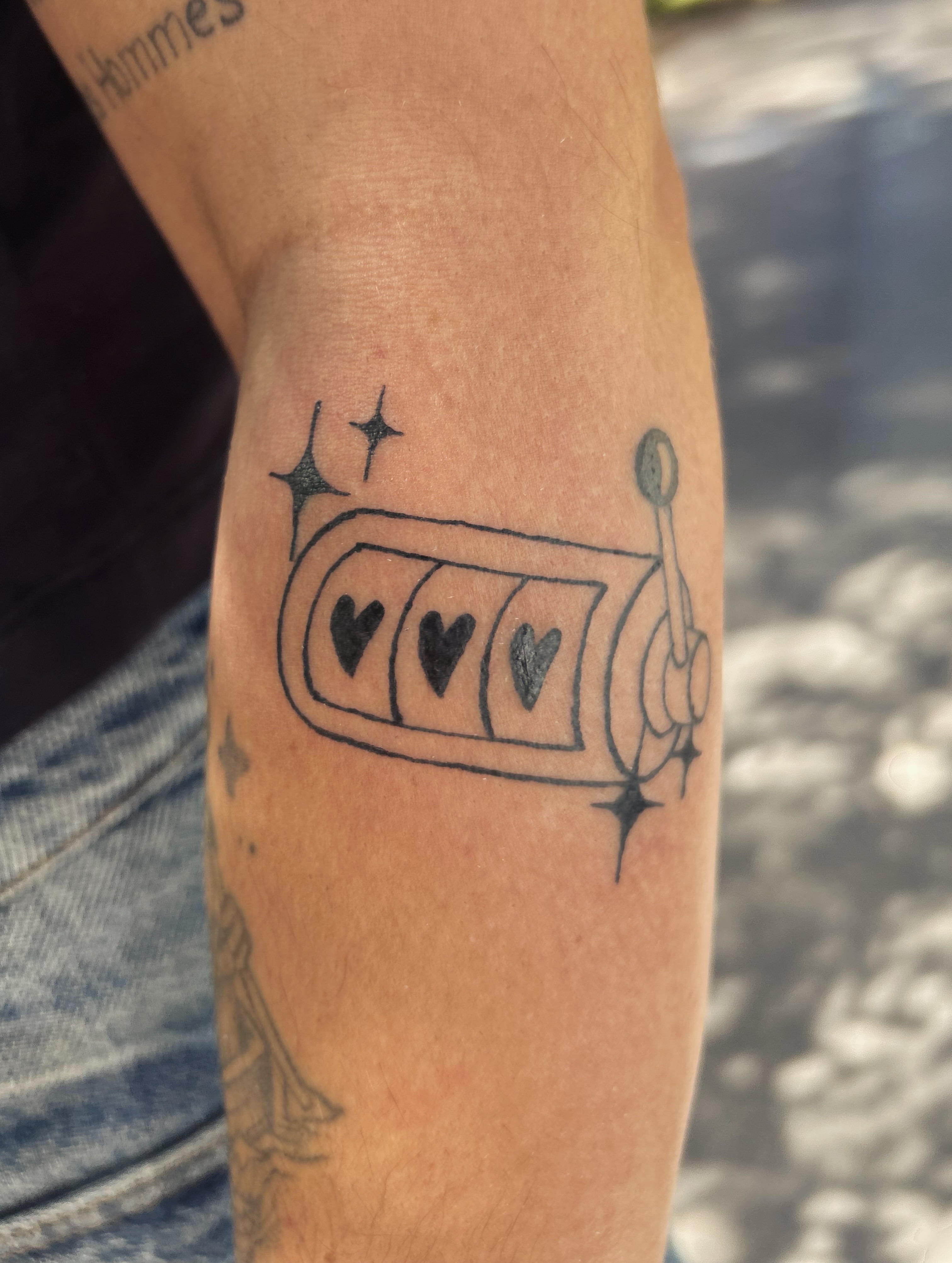 Tatouage machine a sous alignant trois coeurs sur le bras, illustratif